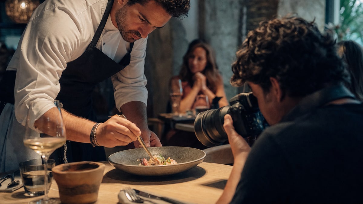 Chef y fotógrafo trabajando sobre un plato de autor. Fotografia generada especificamente para Firekworks.